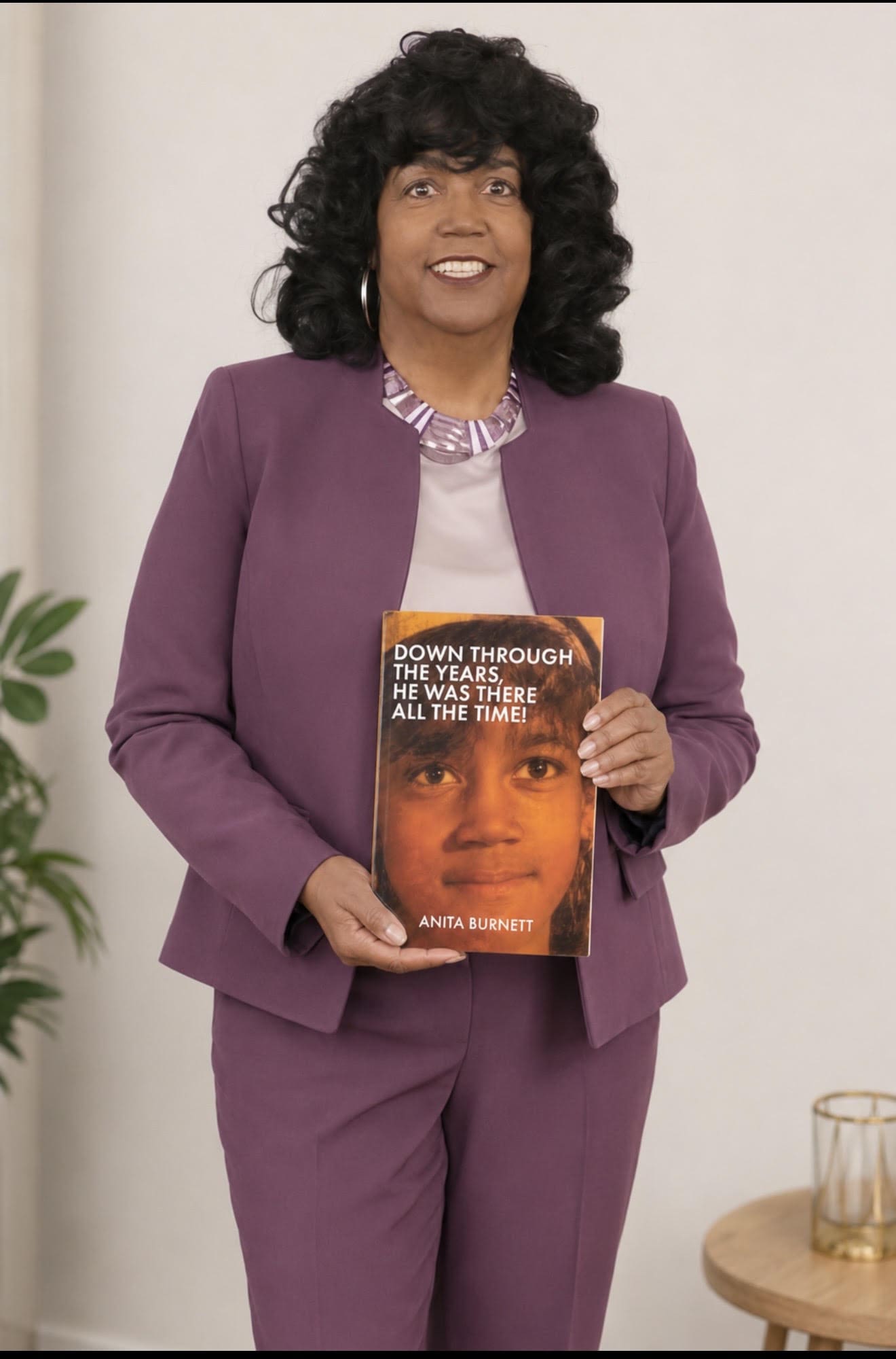 Author Anita Burnett holds her memoir, Down Through the Years, He Was There All the Time!